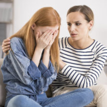 A female psychiatrist comforting a female 
