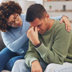 A female psychiatrist comforting a man having problems