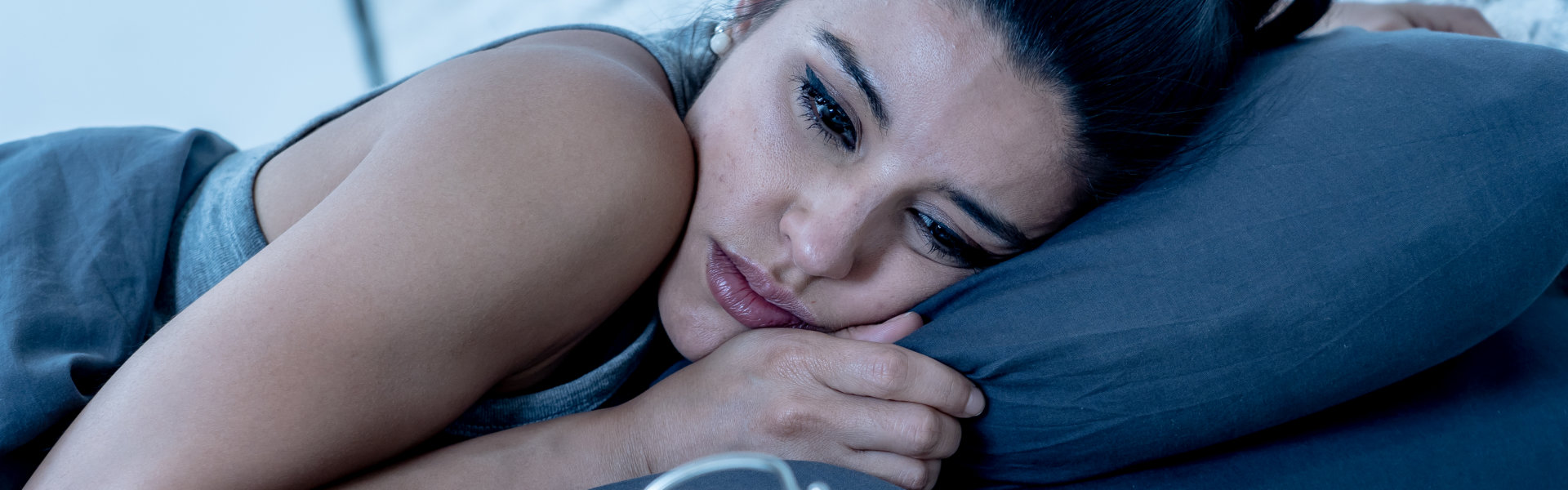 A female laying on the bed showing a sleep disorder